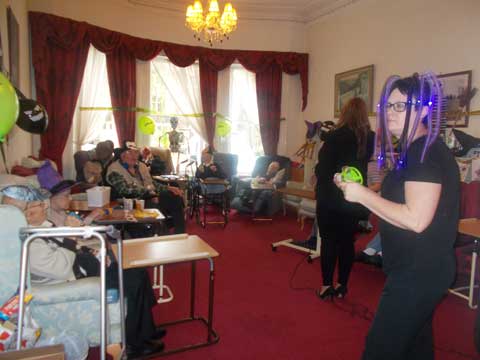 close-up of two residents in party hats smiling and enjoying the group party